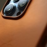 a close up shot of an iphone with brown leather case